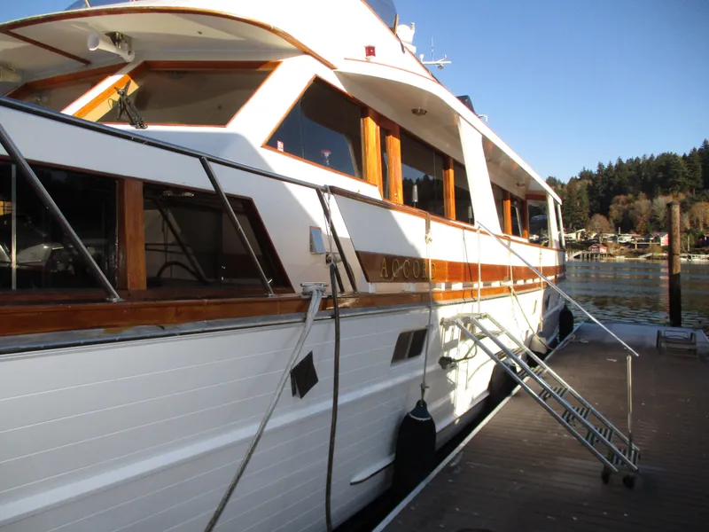 Slide: The Image of 1984 McQueen Flush Deck Motoryacht docked, showcasing elegant wooden accents and sleek design. - 8