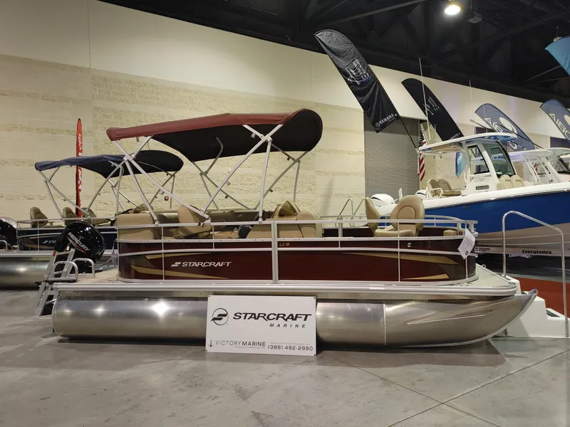 Slide: The Image of 2024 Starcraft EX 18 F pontoon boat on display at a boat show. - 3