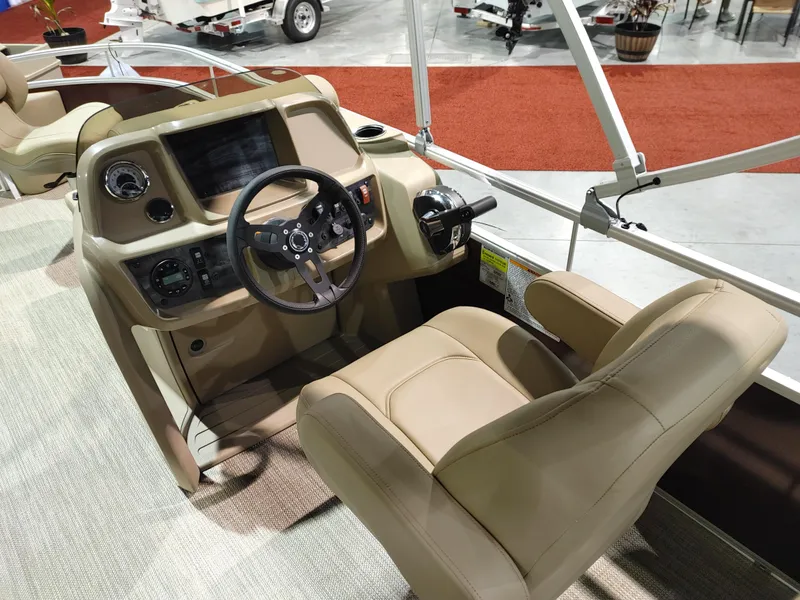 Slide: The Image of 2024 Starcraft EX 18 F boat cockpit with beige captain's chair and control panel. - 5