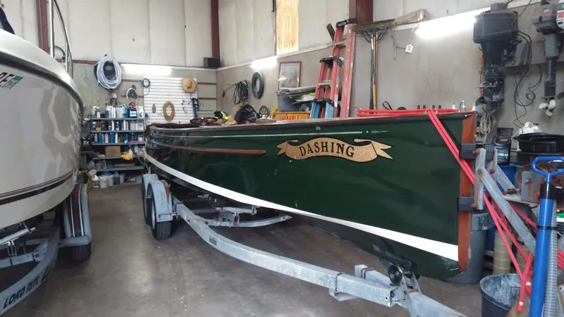 Slide: The Image of Custom 1990 29 Launch boat named Dashing in a workshop on a trailer. - 1