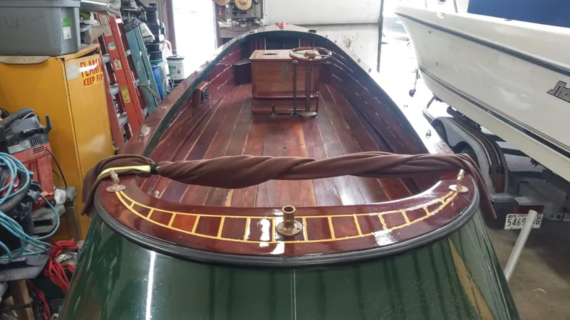 Slide: The Image of Custom 1990 29 Launch boat with polished wooden interior in a garage. - 10