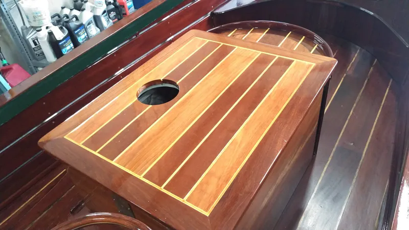 Slide: The Image of Custom 1990 29 Launch boat with polished wooden deck and storage compartment. - 12