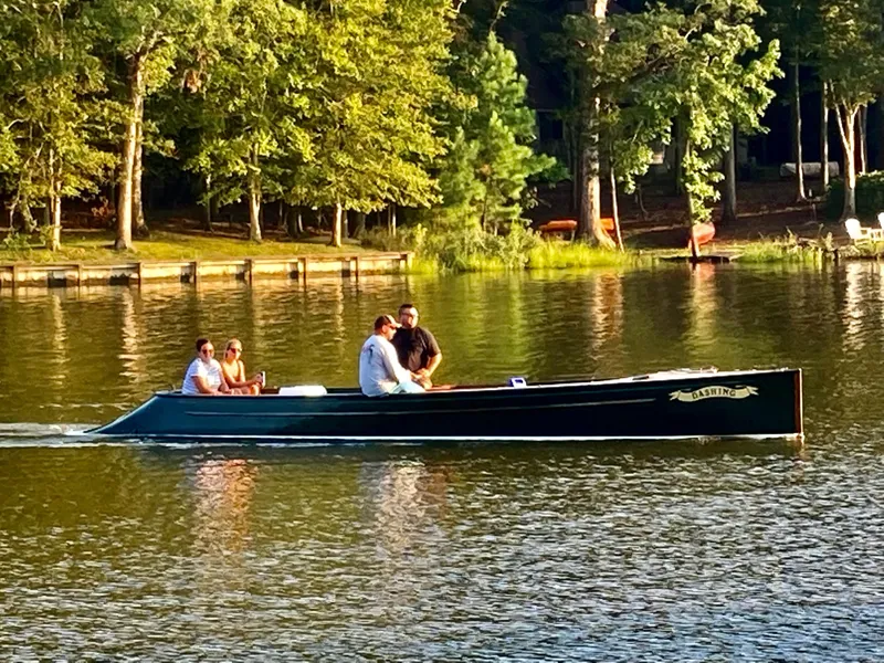 Slide: The Image of People enjoying a ride on a 1990 Custom 29 Launch boat on a serene lake. - 20