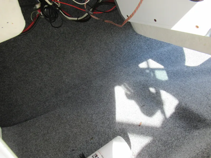 Slide: The Image of Interior carpeted floor of a 2015 Yamaha Boats AR192, showing wiring and shadows. - 14