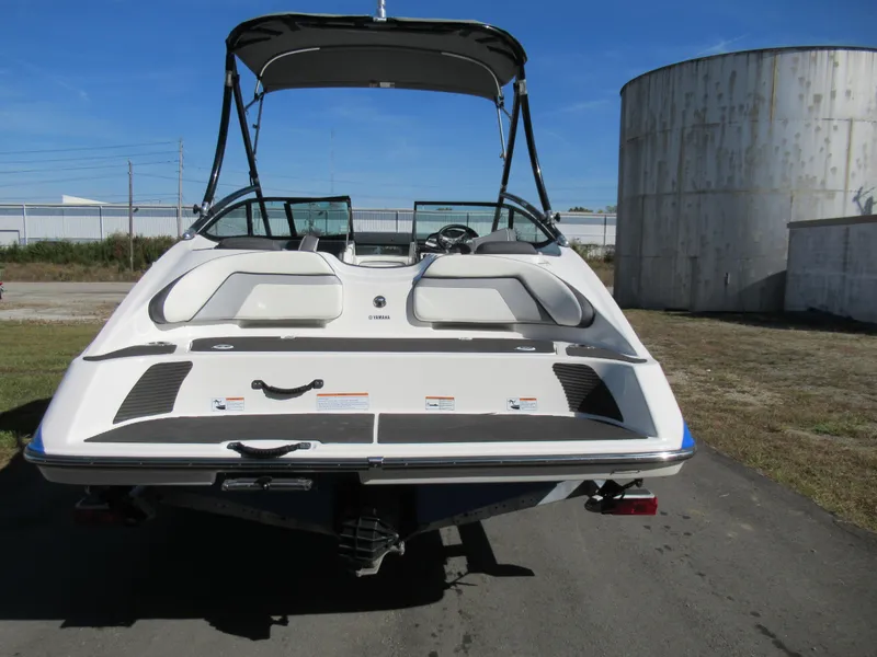 Slide: The Image of 2015 Yamaha Boats AR192, rear view, on pavement with industrial background. - 2