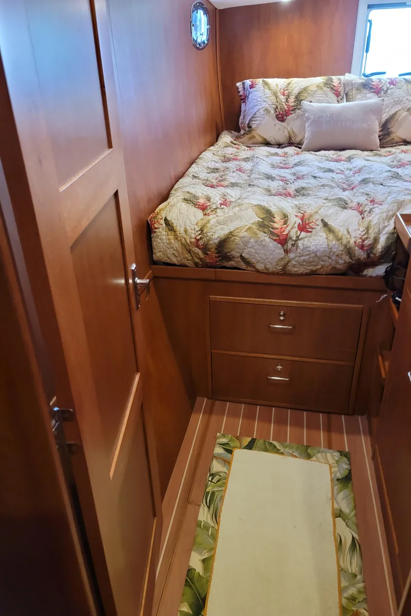 Slide: The Image of Cozy bedroom in 2019 Endeavour Catamaran 440 HYBRID with wooden interior and floral bedding. - 2