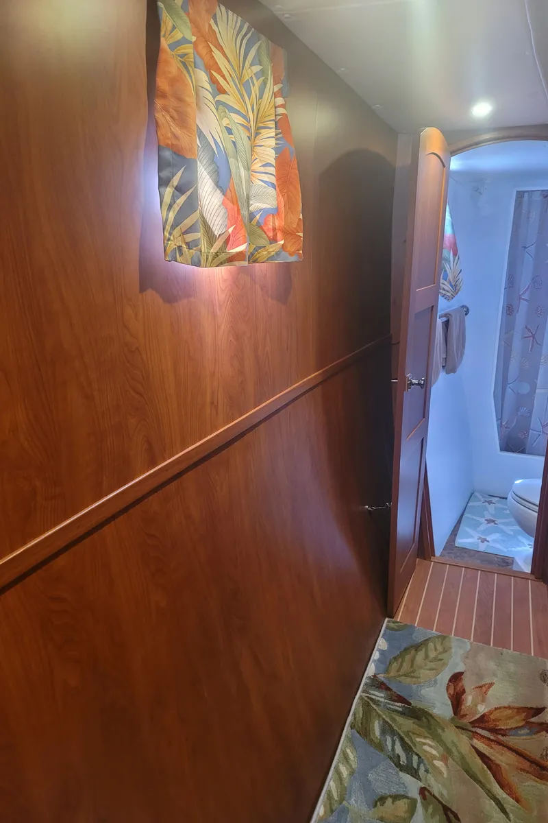 Slide: The Image of Interior hallway of 2019 Endeavour Catamaran 440 HYBRID with wooden paneling and tropical decor. - 8