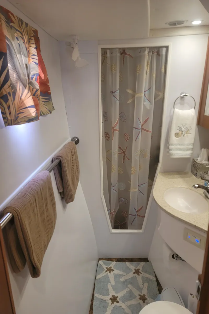 Slide: The Image of 2019 Endeavour Catamaran 440 HYBRID bathroom with shower, sink, and tropical decor. - 9