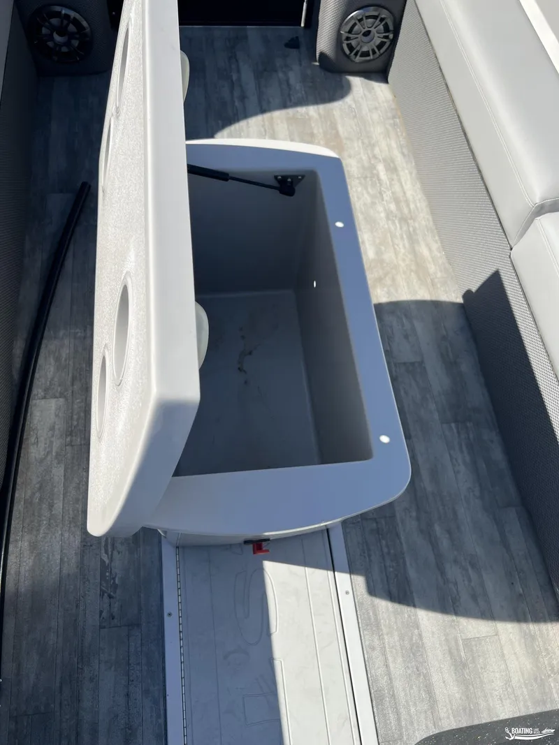 Slide: The Image of Open storage compartment on 2023 Crest 240 Classic Platinum boat with gray flooring. - 7