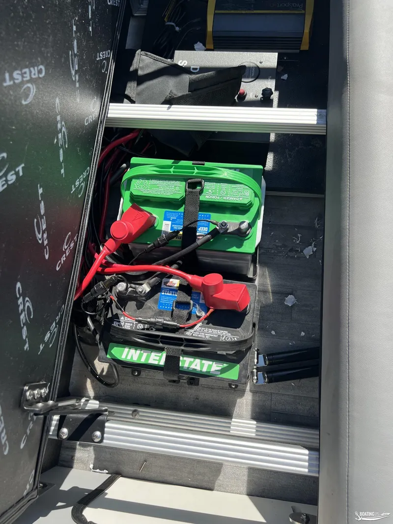 Slide: The Image of 2023 Crest 240 Classic Platinum boat battery compartment with Interstate batteries. - 8
