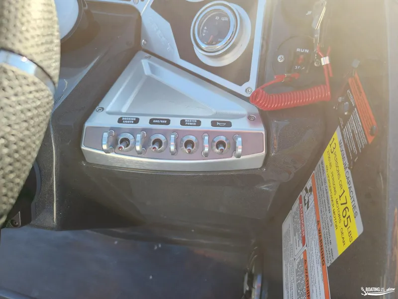 Slide: The Image of Control panel of 2023 Crest Caribbean RS 250 SLS boat with switches and safety labels. - 12