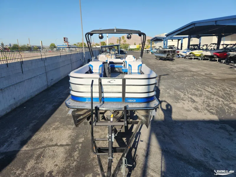 Slide: The Image of 2023 Crest Caribbean RS 250 SLS pontoon boat on trailer in outdoor lot. - 2