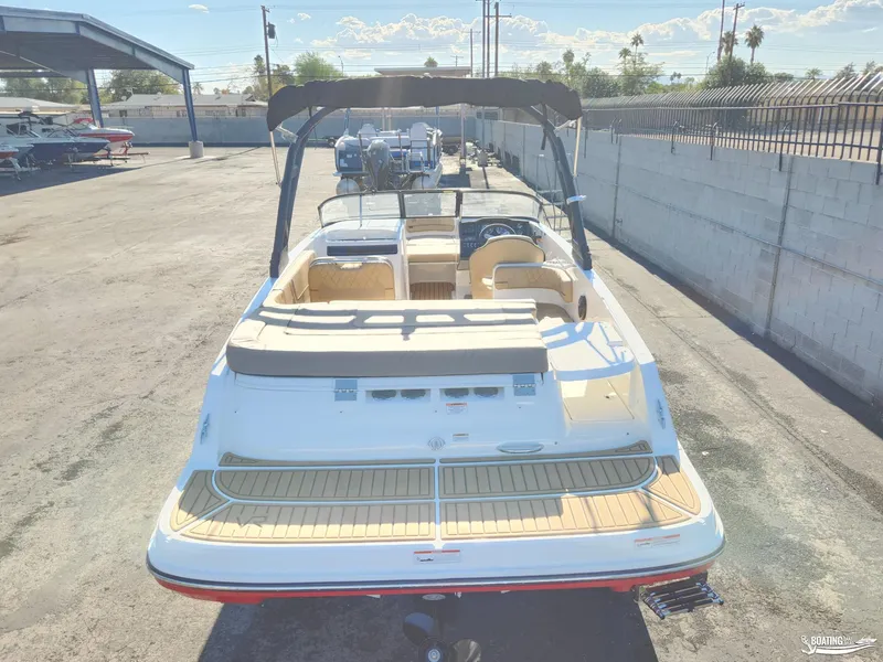 Slide: The Image of 2023 Bayliner VR6 boat with spacious deck and seating, parked outdoors. - 9