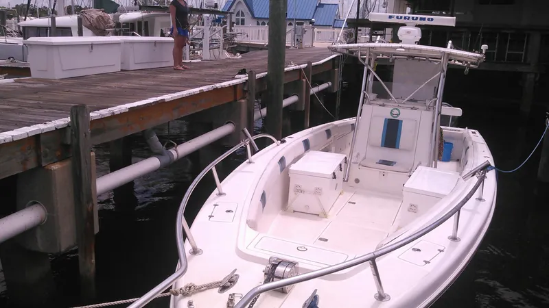 Slide: The Image of 2000 Al Dhaen 360 Open Fisher boat docked at a marina with a person standing on the pier. - 10