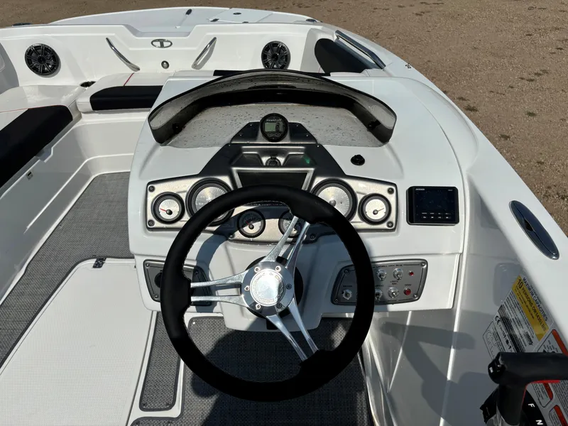 Slide: The Image of 2023 Tahoe 1950 boat dashboard with steering wheel and control panel. - 11
