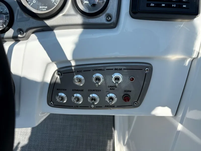 Slide: The Image of Dashboard controls of a 2023 Tahoe 1950 boat, featuring various switches and gauges. - 12