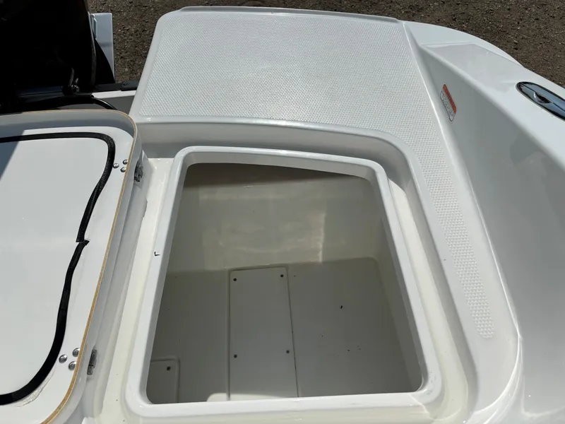 Slide: The Image of Open storage compartment on 2023 Tahoe 1950 boat, featuring white interior and textured lid. - 19