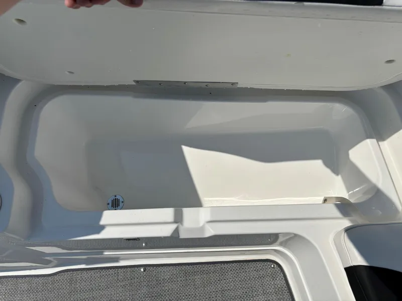 Slide: The Image of Open storage compartment in 2023 Tahoe 1950 boat, featuring a clean, white interior. - 22