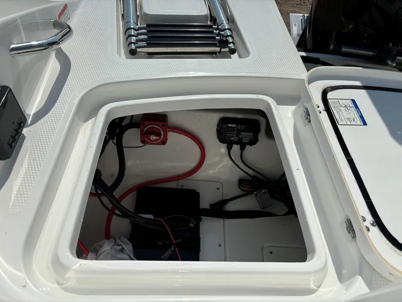 Slide: The Image of Open storage compartment in 2023 Tahoe 1950 boat, showing wiring and battery setup. - 24