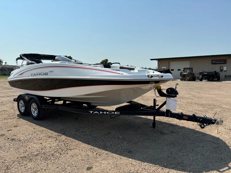 Slide: The Image of 2023 Tahoe 1950 boat on trailer, parked outdoors under clear sky. - 3