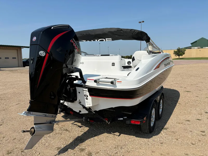 Slide: The Image of 2023 Tahoe 1950 boat on trailer, featuring powerful outboard motor, parked on gravel. - 5