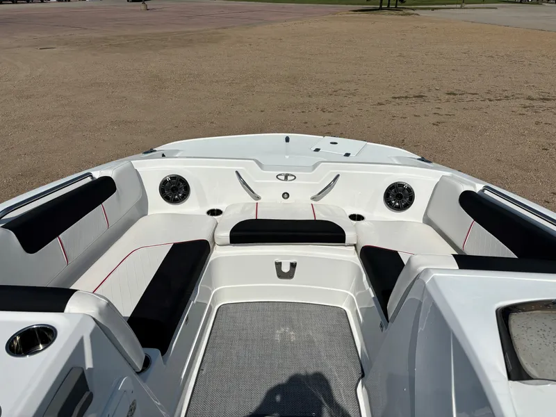 Slide: The Image of 2023 Tahoe 1950 boat interior with seating and speakers, parked on sandy ground. - 8