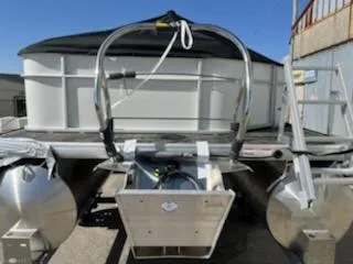 Slide: The Image of 2023 Sweetwater 2086C pontoon boat rear view with motor and ladder. - 9