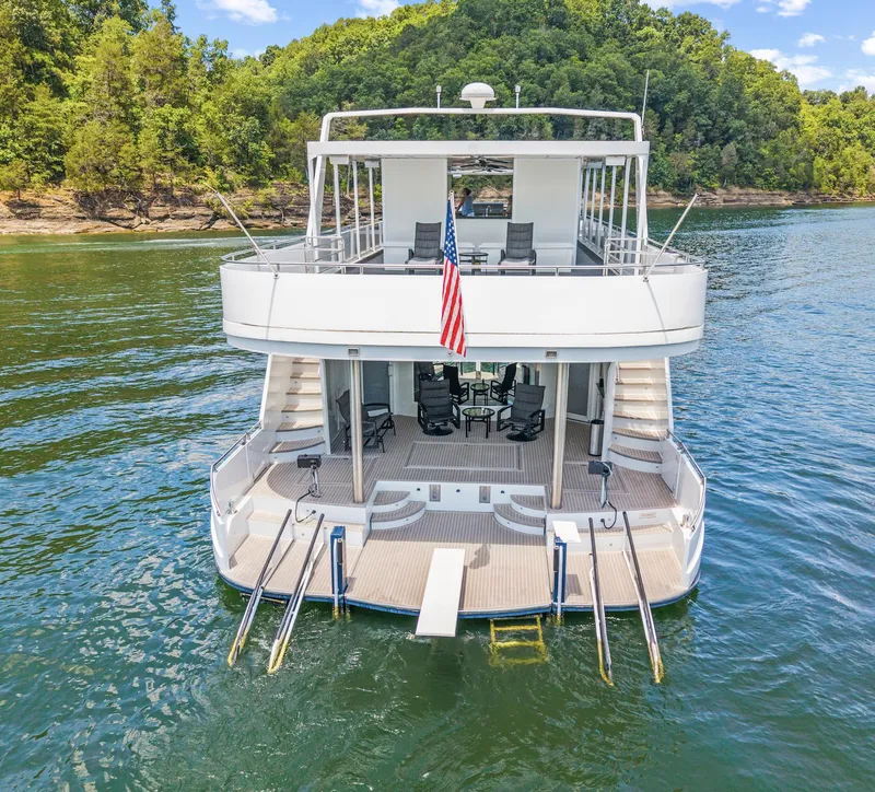 Slide: The Image of Luxurious 2009 Sumerset houseboat on serene lake, featuring spacious decks and elegant design. - 11