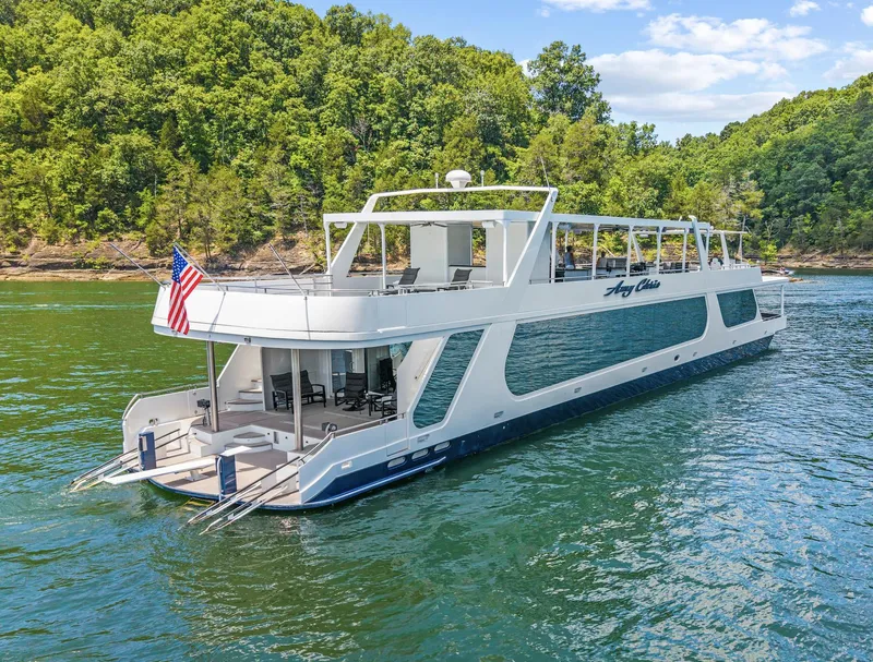 Slide: The Image of Luxurious 2009 Sumerset 23' x 118' houseboat on a scenic lake with lush green surroundings. - 2