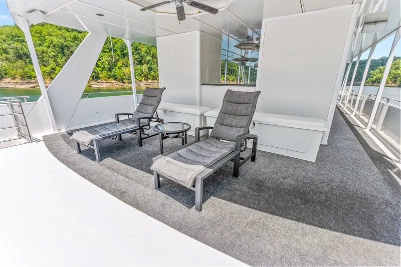 Slide: The Image of Luxurious 2009 Sumerset houseboat deck with lounge chairs, table, and scenic lake view. - 23