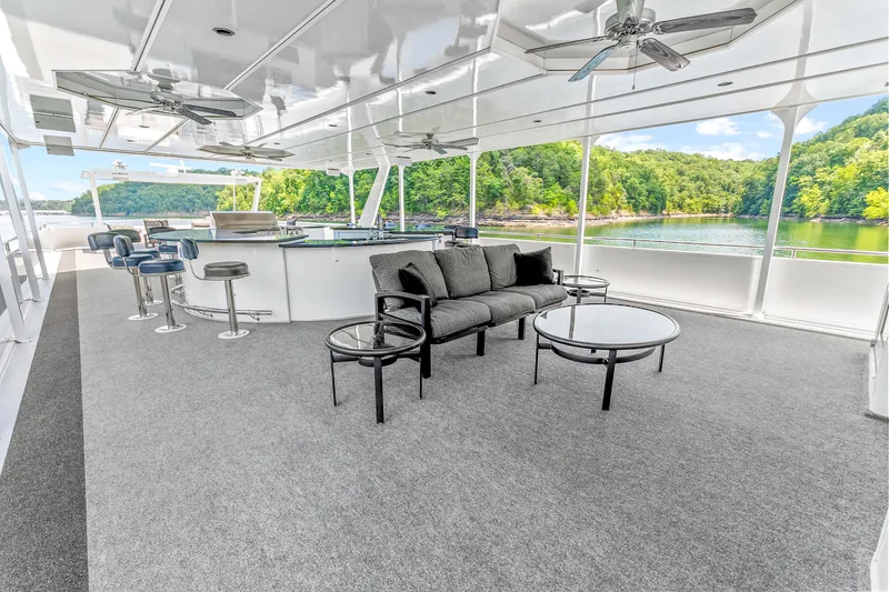 Slide: The Image of Luxurious 2009 Sumerset houseboat interior with seating, bar stools, and scenic lake view. - 26