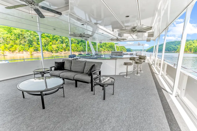 Slide: The Image of Luxurious 2009 Sumerset houseboat deck with seating, bar stools, and scenic lake views. - 27