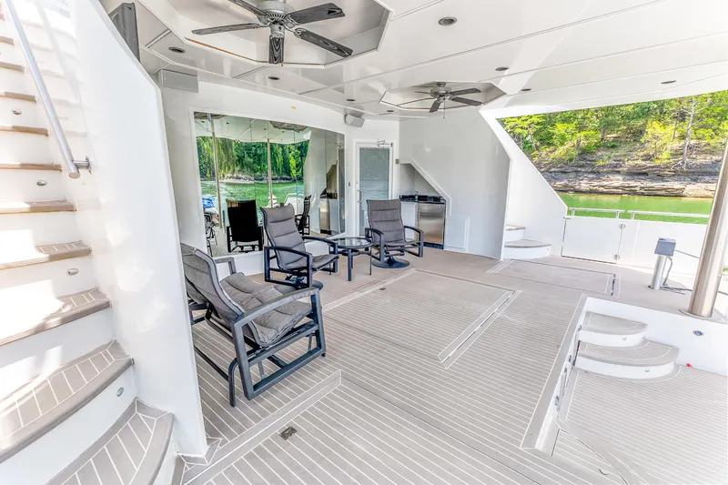 Slide: The Image of Luxurious 2009 Sumerset houseboat deck with seating, ceiling fans, and scenic lake view. - 39