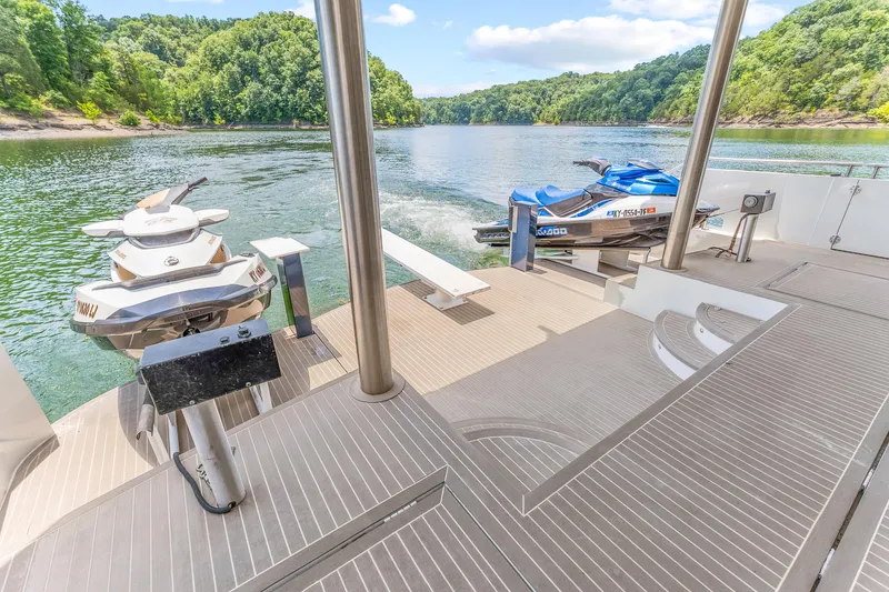 Slide: The Image of 2009 Sumerset houseboat deck with jet skis on a scenic lake. - 41