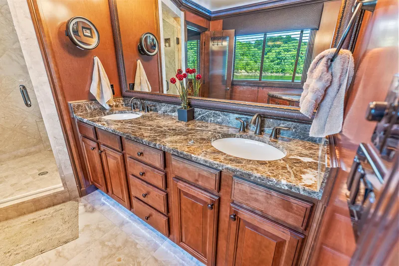 Slide: The Image of Luxurious bathroom with dual sinks, marble countertop, and wooden cabinetry in a 2009 Sumerset houseboat. - 45