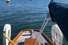 Slide: The Image of 1958 Custom Larson 40 sailboat on calm water, featuring wooden deck and life rings. - 15