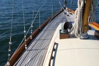 Slide: The Image of 1958 Custom Larson 40 sailboat deck with ropes, sailing on calm waters. - 17