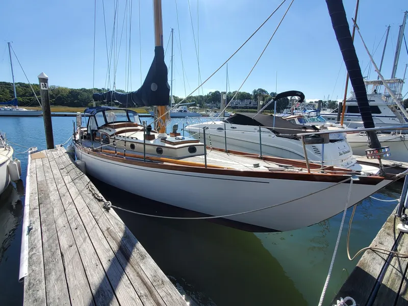 Slide: The Image of Vintage 1958 Custom Larson 40 sailboat docked at a marina on a sunny day. - 19