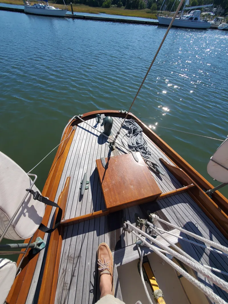 Slide: The Image of 1958 Custom Larson 40 sailboat deck with wooden finish, docked on calm water. - 21