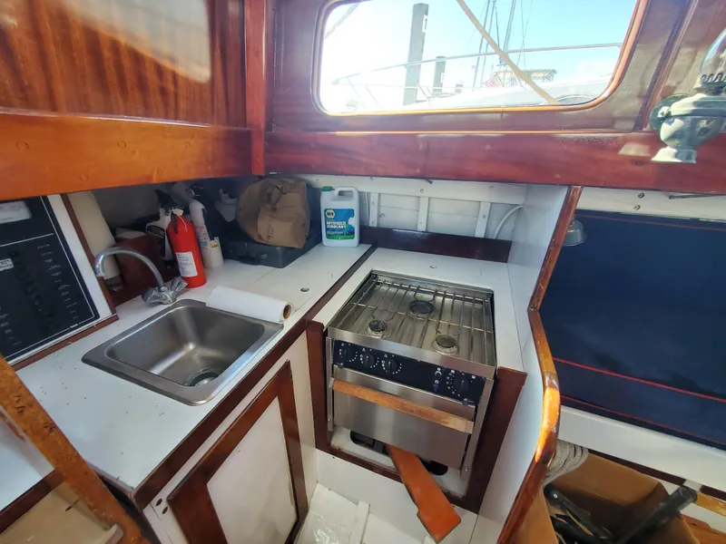 Slide: The Image of 1958 Custom Larson 40 yacht kitchen with sink, stove, and wooden cabinetry. - 3