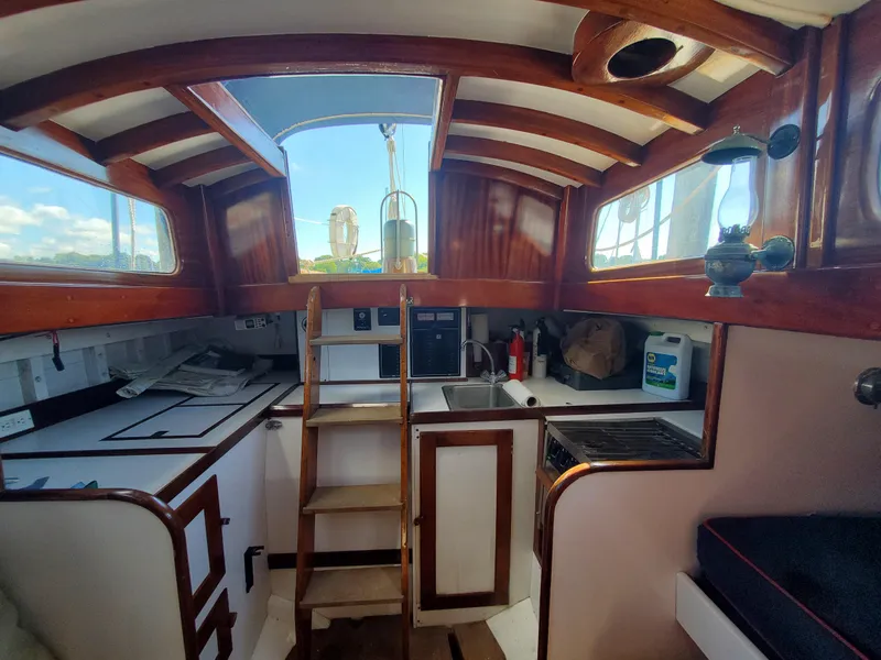 Slide: The Image of 1958 Custom Larson 40 boat interior with wooden accents and compact kitchen area. - 5