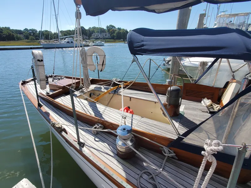 Slide: The Image of 1958 Custom Larson 40 sailboat docked at a marina, featuring classic wooden deck and canopy. - 8