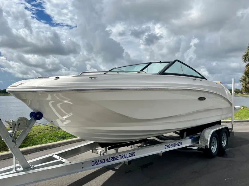 Slide: The Image of 2020 Sea Ray SDX 250 boat on a trailer by the waterfront. - 11
