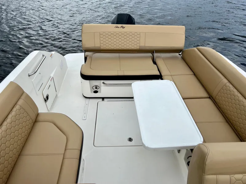 Slide: The Image of 2020 Sea Ray SDX 250 boat with tan leather seating and white table on water. - 22