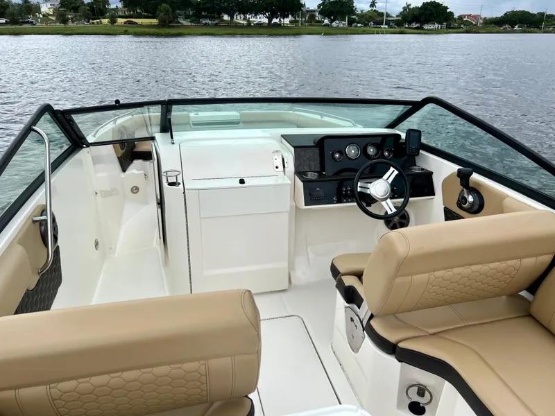 Slide: The Image of 2020 Sea Ray SDX 250 boat interior with tan seating and black dashboard. - 25