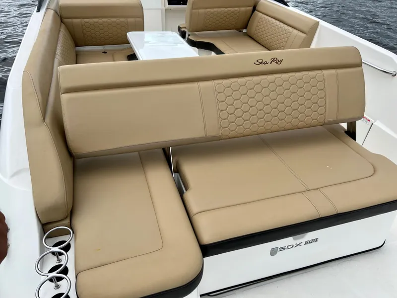 Slide: The Image of 2020 Sea Ray SDX 250 boat interior with beige seating and cup holders. - 29