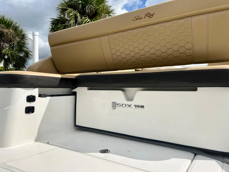 Slide: The Image of 2020 Sea Ray SDX 250 boat interior with tan seating and logo. - 8