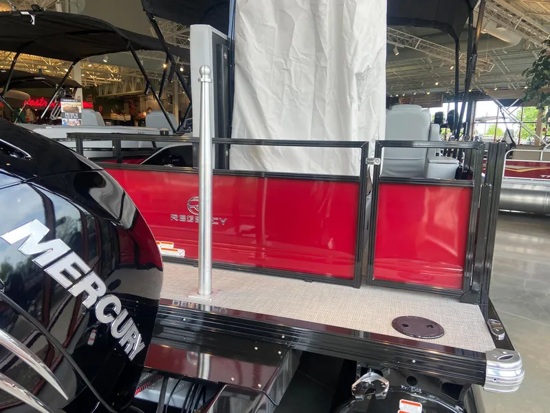 Slide: The Image of 2023 Regency 250 DL3 pontoon boat with Mercury engine, red and black design. - 2