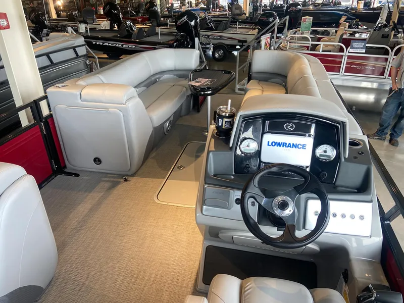 Slide: The Image of 2023 Regency 250 DL3 pontoon boat interior with plush seating and Lowrance navigation system. - 3