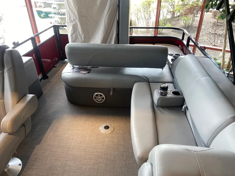 Slide: The Image of 2023 Regency 250 DL3 pontoon boat interior with gray seating and cup holders. - 4